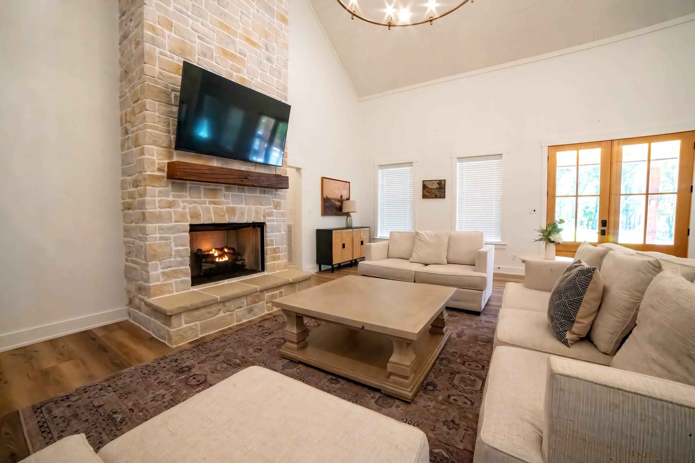 Main floor stone fireplace with fire lit