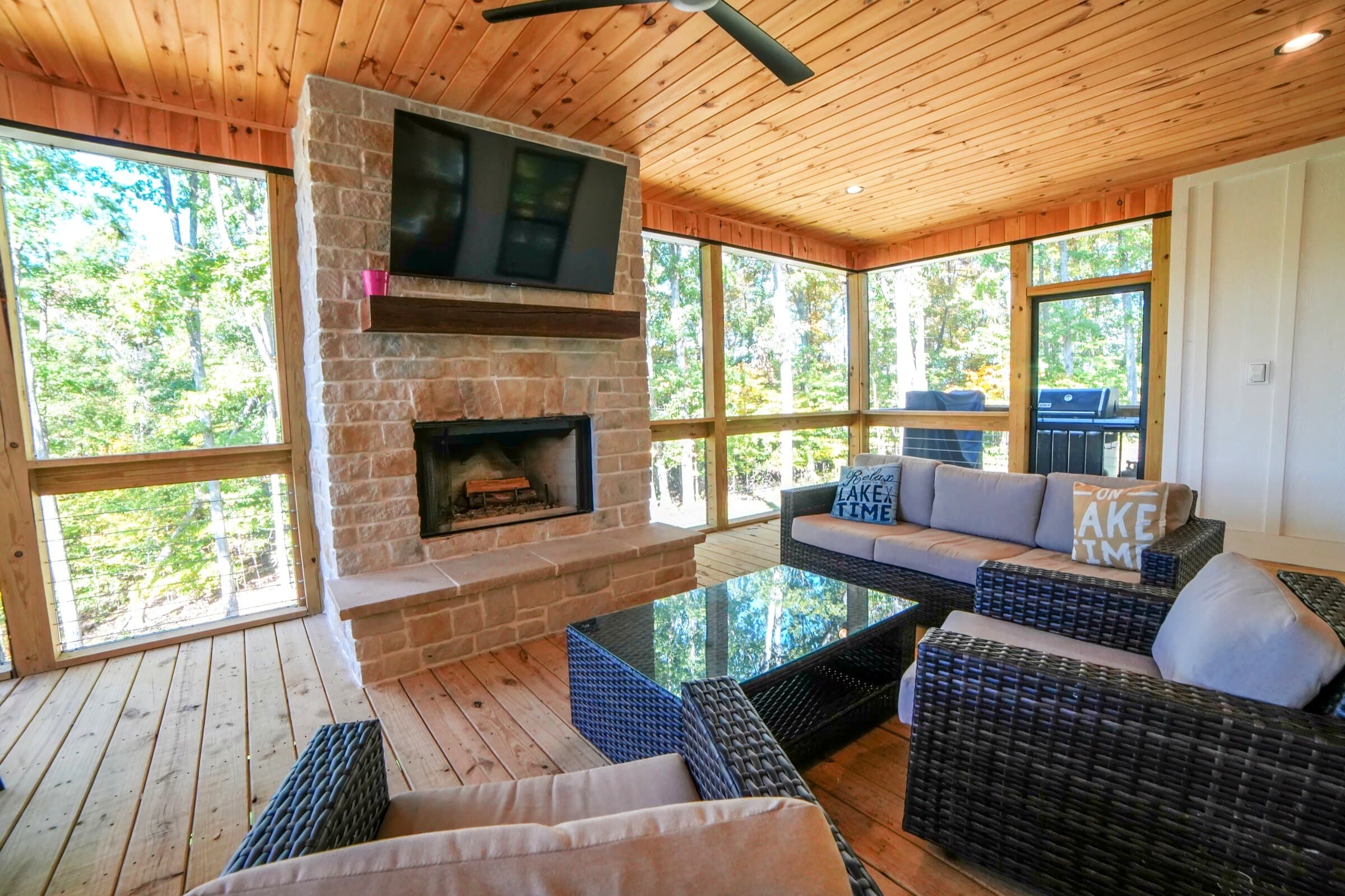 The upper screened porch with the stone fireplace lit